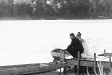 Nah Achern nimmt sich die Braut paar eine Auszeit vom Hochzeitsfest und verweilt am Ende einer Steg und betrachtet das Spiel von Wasser und Licht, während sie von eine romantische Gegenlicht von der abendliche Sonne umwaschen werden.